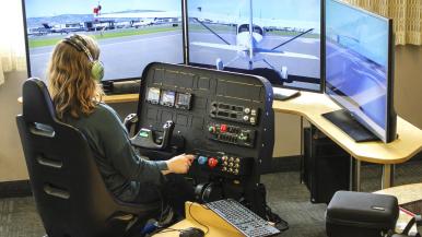 image of person sitting at flight simulator stations