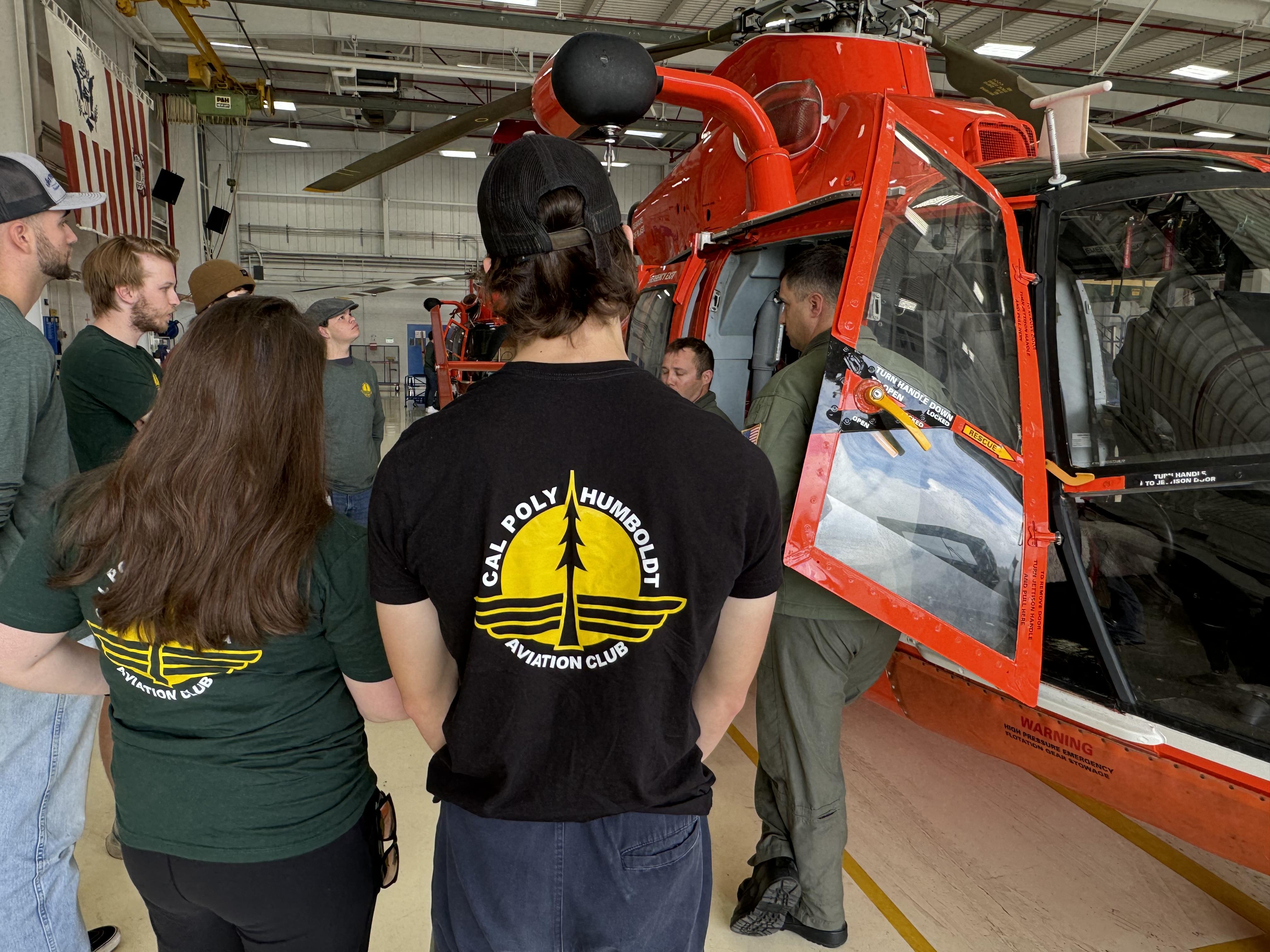 image of students in aviation club looking at Coast Guard helicopter